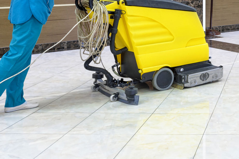 ポリッシャーでビルの床清掃をしている清掃員